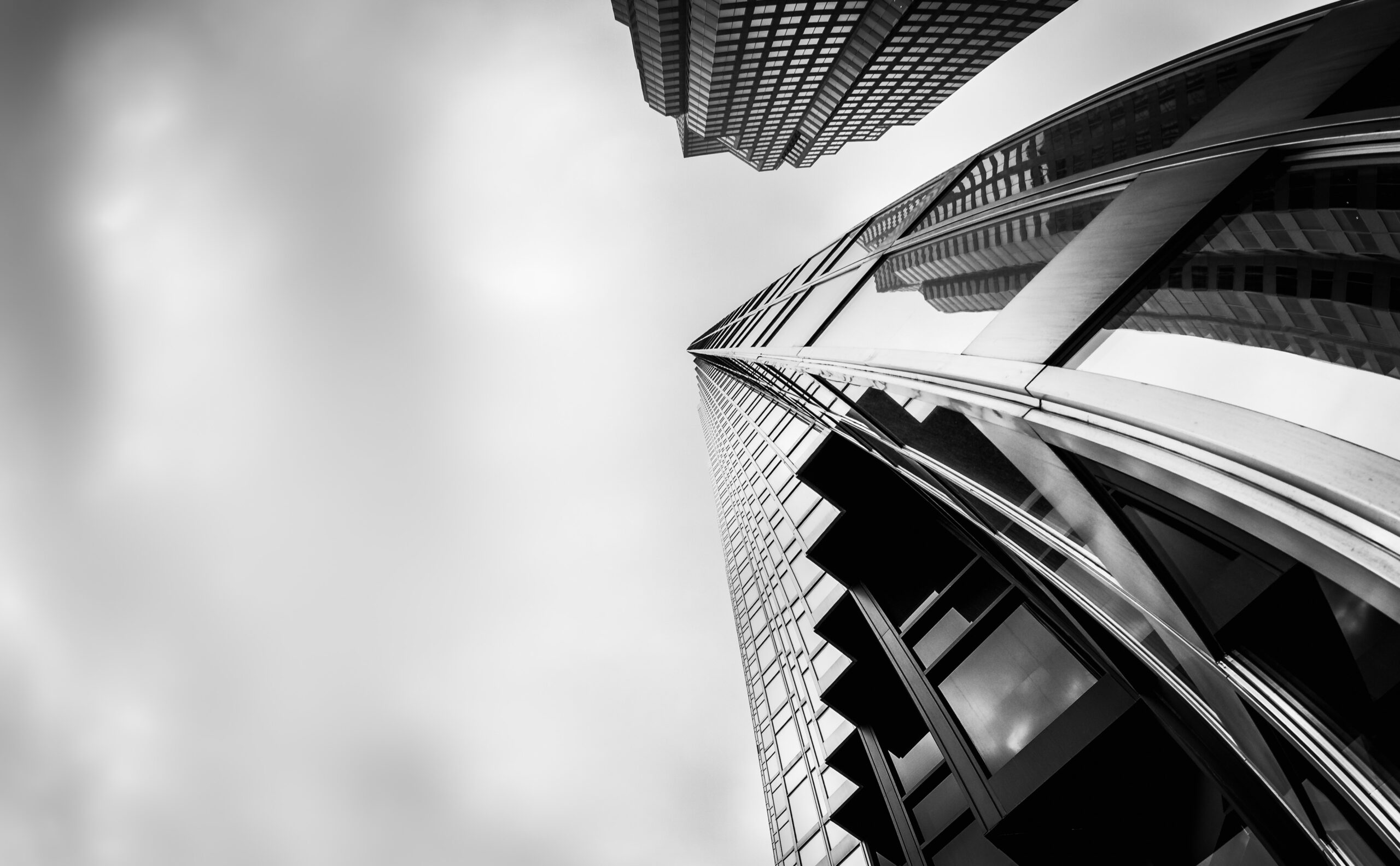 A greyscale low angle shot of high-rise buildings in the financial district of Toronto Canada under the cloudy sky
